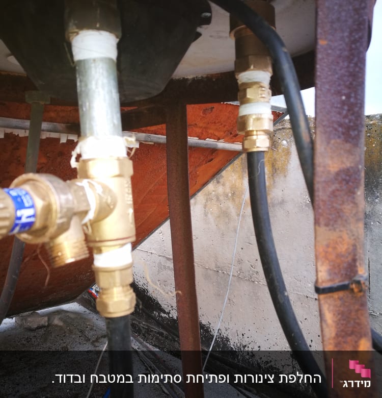 צינורות ומחברים מתכתיים מתחת לכיור